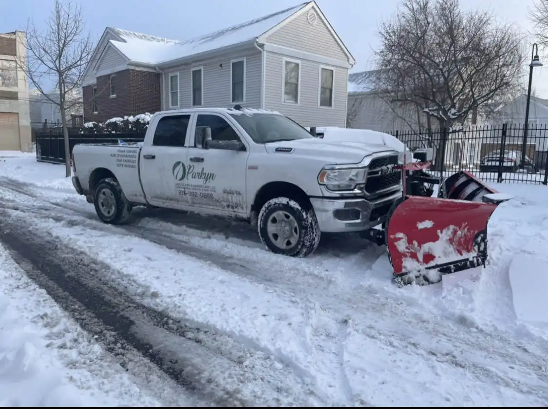 A snow plow truck navigates a snowy road, efficiently removing snow from the surface.