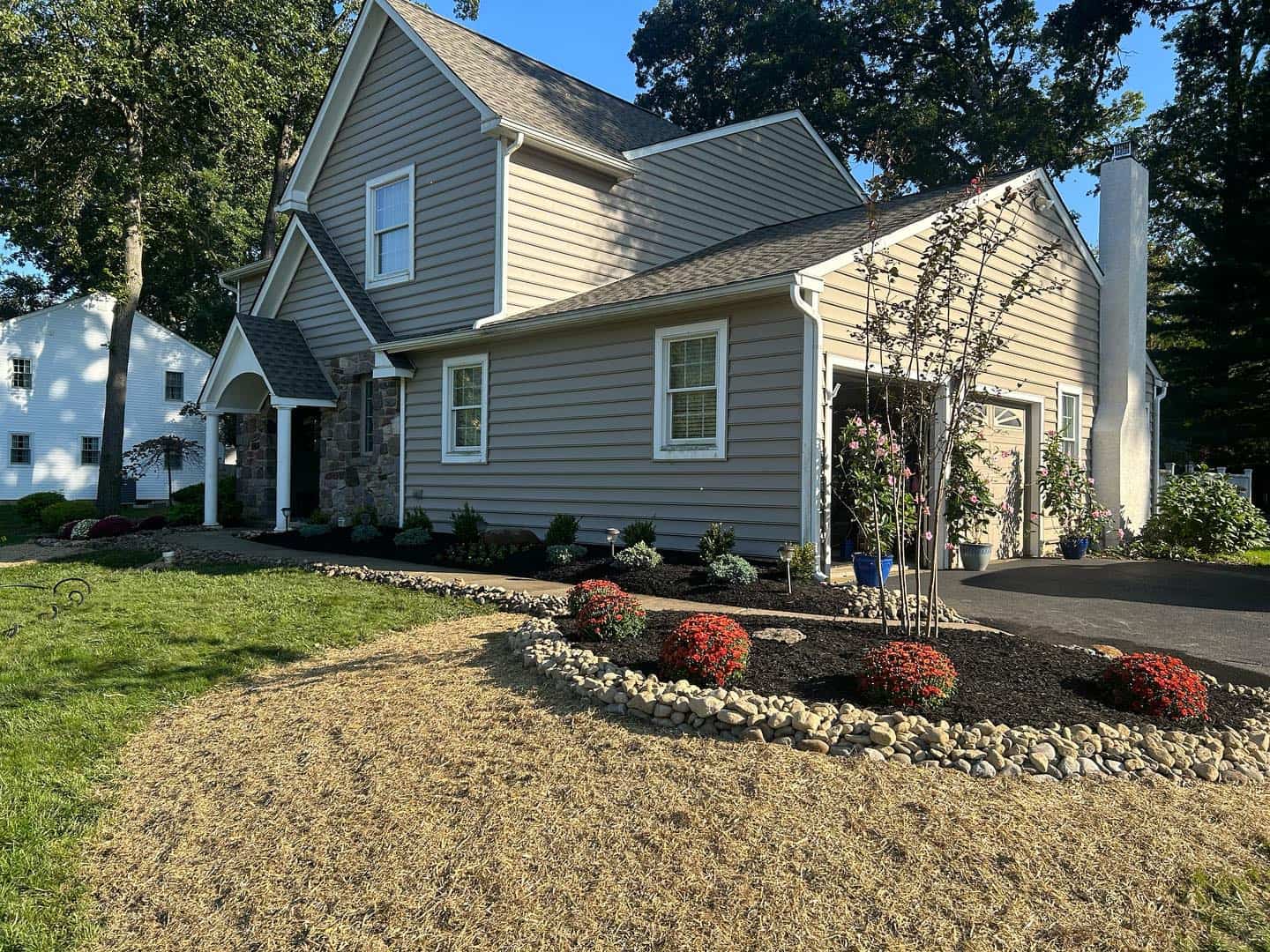 A well-maintained home surrounded by lush landscaping and various landscaping materials, showcasing outdoor design.